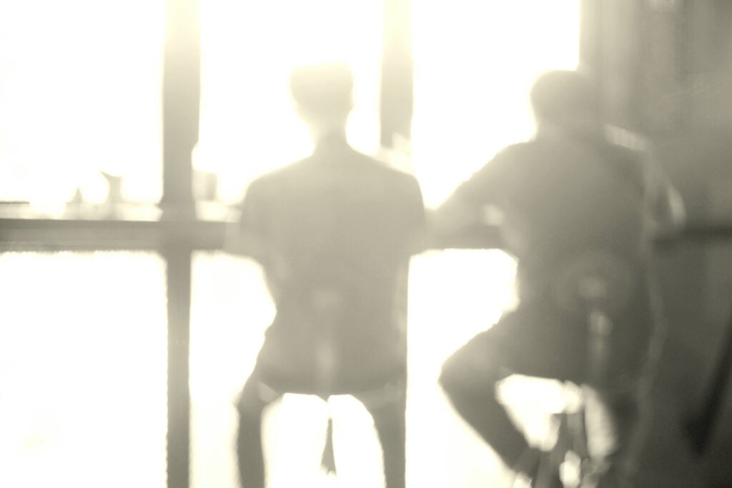 two individuals sitting at counter with backs to viewer